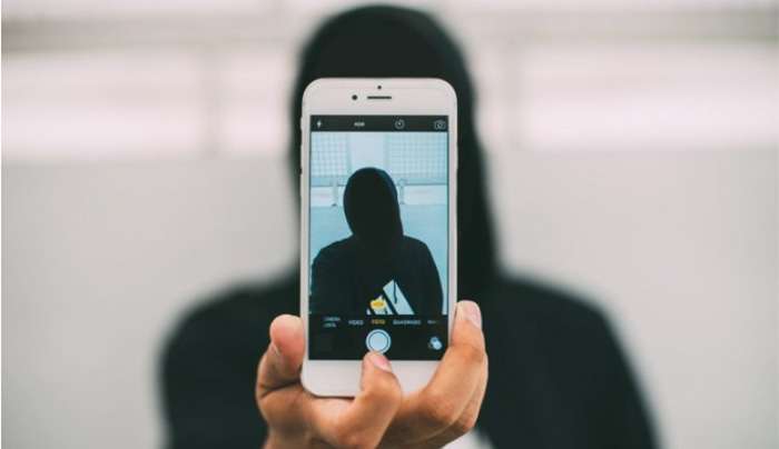 Άτομο κρατά ένα smartphone μπροστά από το πρόσωπό του. (Πηγή: Pexels)